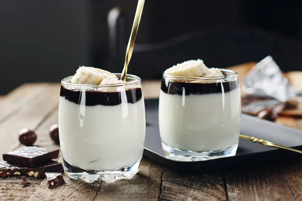 Sütlü tatlı, muzlu ve çikolatalı krema, tahta bir arka planda..