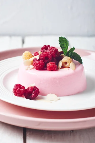 Pembe panna cotta tatlı ve taze ahududu..