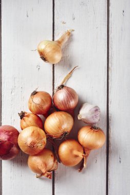 Beyaz ahşap arka planda soğan ve sarımsak..