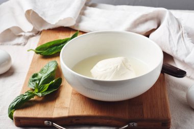 Kase içinde Mozzarella peyniri topu ve taze fesleğen yaprakları..