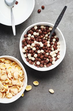 Kahvaltı gevreği ve süt kâseleri. Mısır gevreği ve çikolata topları.