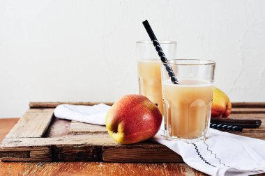 Elma-armut suyu ve ahşap bir masada taze armut..