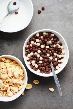 Kahvaltı gevreği ve süt kâseleri. Mısır gevreği ve çikolata topları.