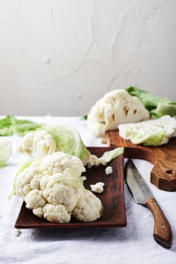 Beyaz masa örtüsü üzerinde taze çiğ karnabahar..