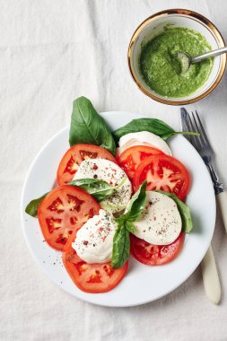 Caprese salatası. Domates, mozarella peyniri, fesleğen yaprağı ve pesto sosu..