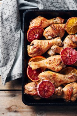 Kızarmış tavuk budu kızartma tavasında. Portakallı tavuk budu..