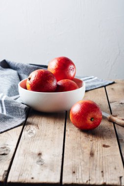 Tahta masadaki bir kasede taze kırmızı kan portakalları..