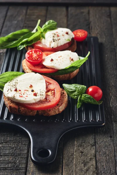 Open Sandwiches Bruschetta Mozzarella Cheese Tomatoes Basil Caprese Dark Wooden — Stock Photo, Image