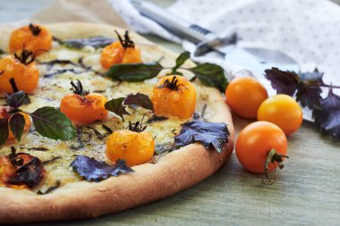 Sarı kiraz domatesli pizza, peynir ve fesleğen..