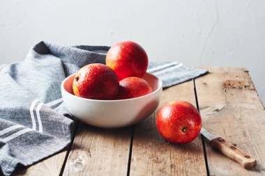 Tahta masadaki bir kasede taze kırmızı kan portakalları..
