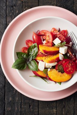 Domatesli salata, şeftali, kırmızı soğan, peynir ve fesleğen. Üst görünüm.