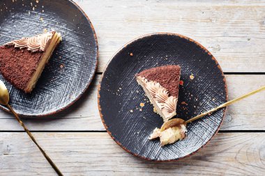 İki dilim çikolatalı kek, siyah tabakta, en üstte..