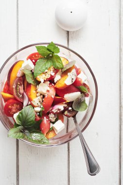 Domatesli salata, şeftali, kırmızı soğan, peynir ve fesleğen. Üst görünüm.