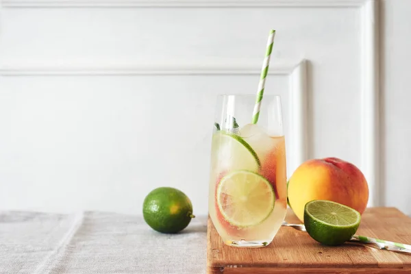 Lime peach drink, summer non-alcoholic cocktail in a glass.