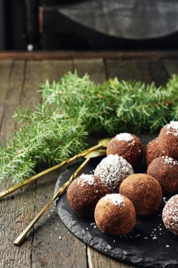 Hindistan cevizi taneli çikolatalı rom topları, koyu arkaplanda tatlı şekerler..