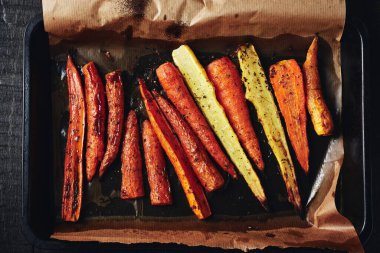 Koyu ahşap arka planda kavrulmuş havuç kızartma tenekesi..