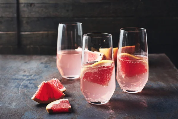 Koyu arkaplanda bir bardakta greyfurt içeceği tazeliyorum..