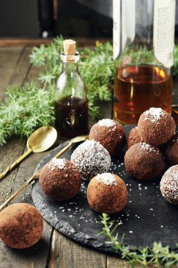 Hindistan cevizi taneli çikolatalı rom topları, koyu arkaplanda tatlı şekerler..