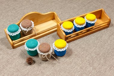 Wooden shelves and multicolored crochet handmade jars of spices clipart