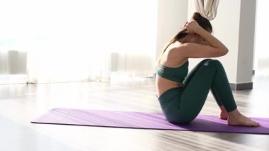 Spor kıyafetleri içinde sportif çekici bir kadın karın egzersizi yapıyor, rock basını egzersizi yapıyor.