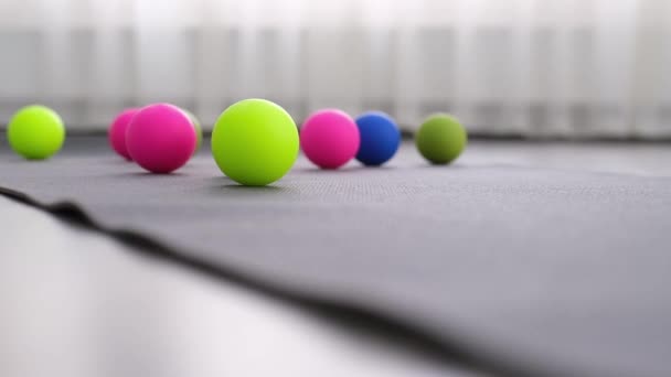 Bolas multicoloridas no tapete de ioga, uma bola para rolos de liberação miofascial no tapete — Vídeo de Stock