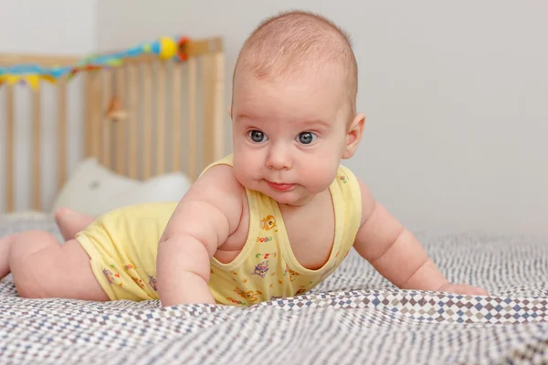 Kleiner Junge mit offenen Augen auf Bauch liegend — Stockfoto