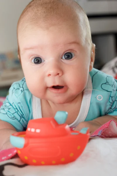 Kleiner Junge mit Spielzeug auf dem Bauch — Stockfoto