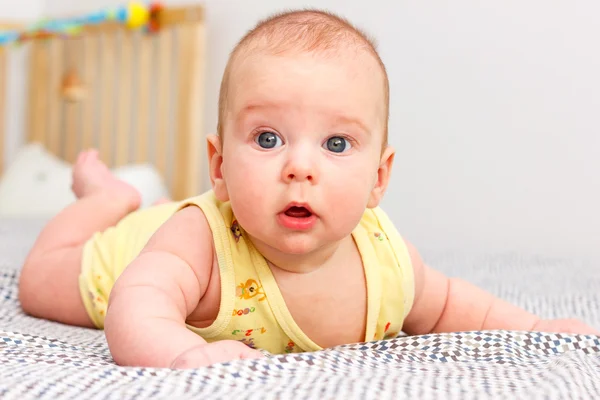 Überraschtes Kleinkind liegt auf der Couch — Stockfoto