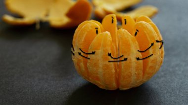 Dilimler, yaratıcı meyve sanatını bir arada tutuyormuş gibi görünen portakalları soyulmuş ellerle kapat.