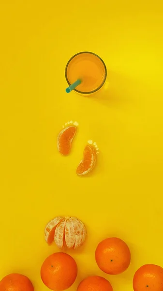 オレンジジュースとオレンジのフラットレイアウトトップビューとジュースグラスフルーツアートのコンセプトに向かって歩いて足跡の形でスライス — ストック写真