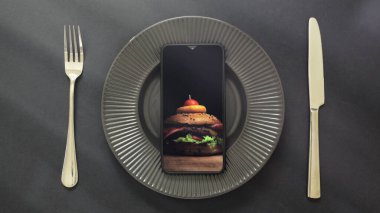 Ekranda hamburgerli akıllı telefon yatağı, paket servis ya da internetten sipariş uygulaması konsepti