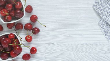 Taze meyveli olgun kirazların su damlacıklarıyla dolu kasede düz bir görünümü vardı. Taze antioksidan diyeti Yaz meyveleri