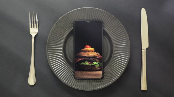 Ekranda hamburgerli akıllı telefon yatağı, paket servis ya da internetten sipariş uygulaması konsepti