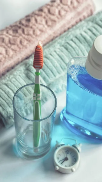 Close-up of mouthwash toothbrush and towels in bathroom morning hygiene routine dental healthcare educational concept