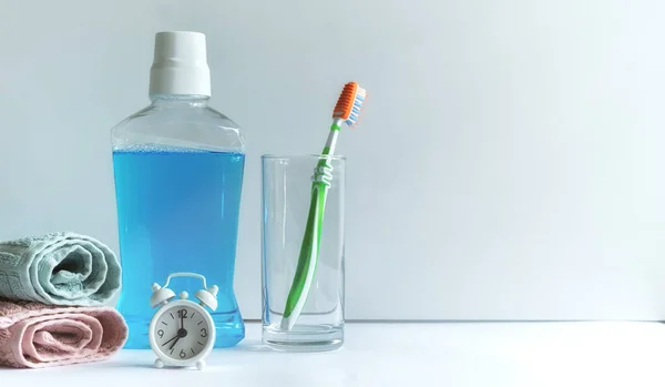 Close-up of mouthwash toothbrush and towels in bathroom morning hygiene routine dental healthcare educational concept