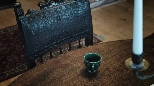 Eski ahşap ahşap koltuklu ahşap masa üzerindeki el yapımı çay bardağının iç tasarımı görüntüsünü kapatın.