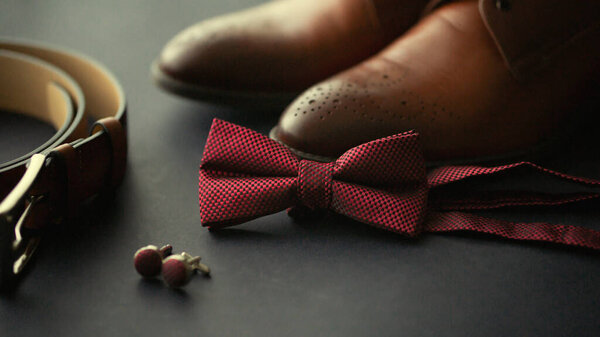 Close up of male wedding groom accessories set .Fashion style boutonniere brown leather shoes and belt and tie blue marine suit