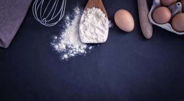 Pişirme tarifi unu ve siyah arka planda çırpılmış yumurta.