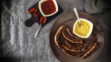 Sebzeli ızgara sosis ve acı kırmızı biberli domates sosu ve hardal.