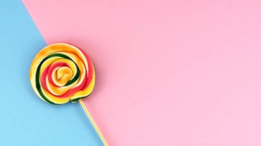 Pembe ve mavi arka plan minimalist kavramının üzerinde düz lolipop yatışı
