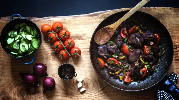 Yemek fotoğrafçısı tavuk ciğeri soğan ve domates soslu güveç.