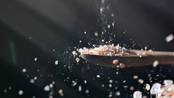 在木勺菜谱调料上加入从上往下倒的喜玛拉雅食盐 — 图库照片