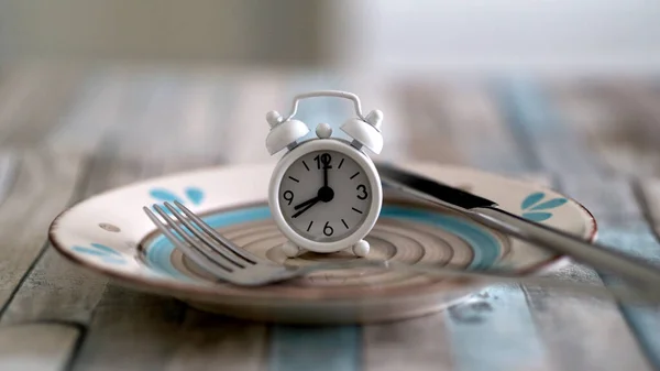 Perhiz konseptindeki aralıklı tabağın alarm saatini kapat. Sağlıklı yaşam tarzı yeme zamanı.