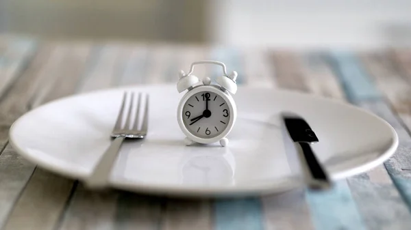 Perhiz konseptindeki aralıklı tabağın alarm saatini kapat. Sağlıklı yaşam tarzı yeme zamanı.