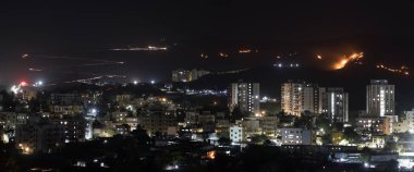 Gece şehir manzarası, uzak yollarda ışık yolları ve diğer tarafta yanan camlar, uzun pozlama manzarası. Doğal vahşi ateş. Binaların çeşitliliği ve ince renkler de var..