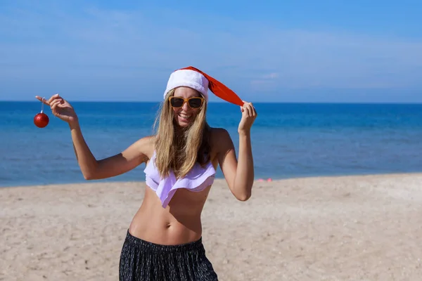 Neujahr Strand Lustiges Mädchen Mit Weihnachtsmütze Und Einem Weihnachtsbaumspielzeug Der — Stockfoto