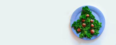 Bir tabakta otlar ve fındıklardan yapılmış Noel ağacı. Yemekten yılbaşı dekorasyonu. Beyaz bir arka planda izole edilmiş. Boşluğu kopyala