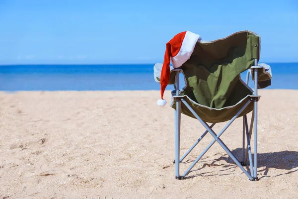 海沿いのビーチでの新年の前夜 観光客の椅子にサンタの帽子 クリスマス休暇だ 暑い国での観光は — ストック写真