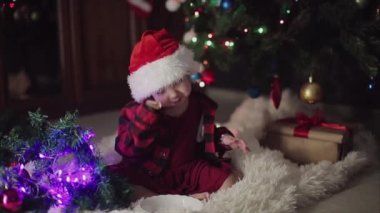 Kırmızı elbiseli bir çocuk yeni yılı bekliyor. Noel 'i gece yarısı kutlama konsepti. tatil kostümü