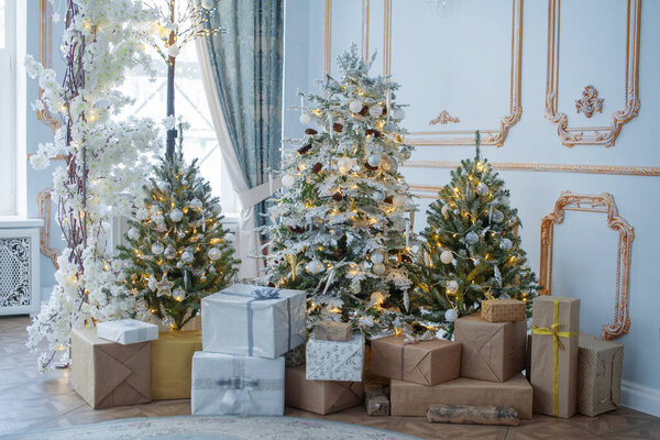 Праздничный интерьер: елка и диван с подушками, подарки. Концепция Рождества и Нового года.